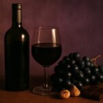 Glass and bottle of Tannat with black grapes, dried figs and dark chocolate