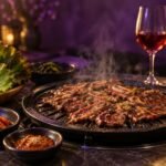 Korean barbecue spread with grilled beef, kimchi and two glasses of wine